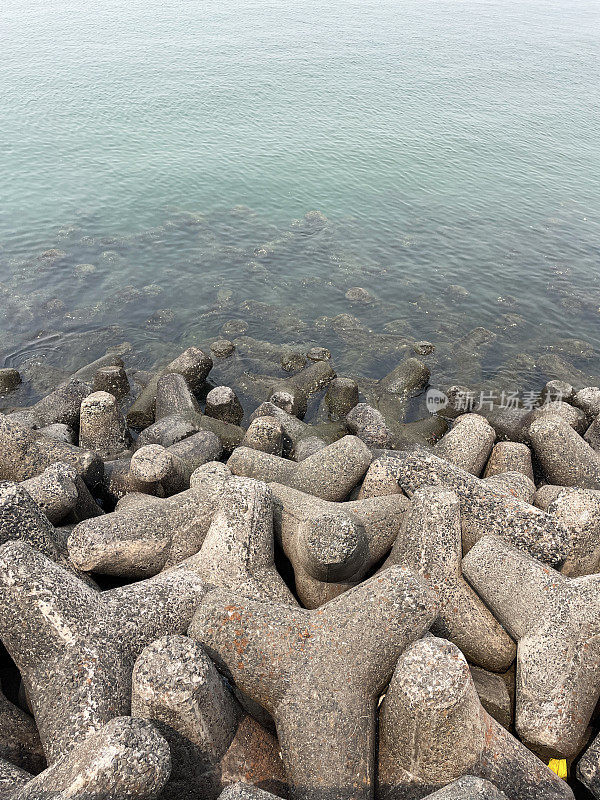 印度孟买的Marine Drive海堤特写图像，环环相扣，混凝土，四足块海防，海岸管理，防止侵蚀，海水和海浪，高架视图，重点放在前景上